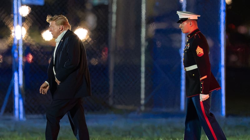 El presidente Donald Trump camina desde el helicóptero presidencial Marine One hasta su...