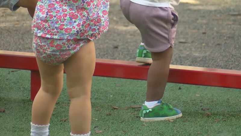 Two children play outside at a childcare facility. A new analysis finds Alabama families need...