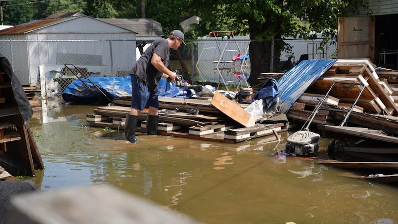 Frank Gounder saca equipo de su taller de carpintería afectado por las inundaciones en...