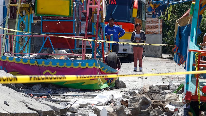 Residents look at the area destroyed by a fireworks explosion by Santa María Canchesdá church...